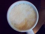 Milchschaum in einem Becher mit Kaffee