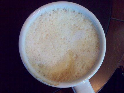 Milchschaum in einem Becher mit Kaffee